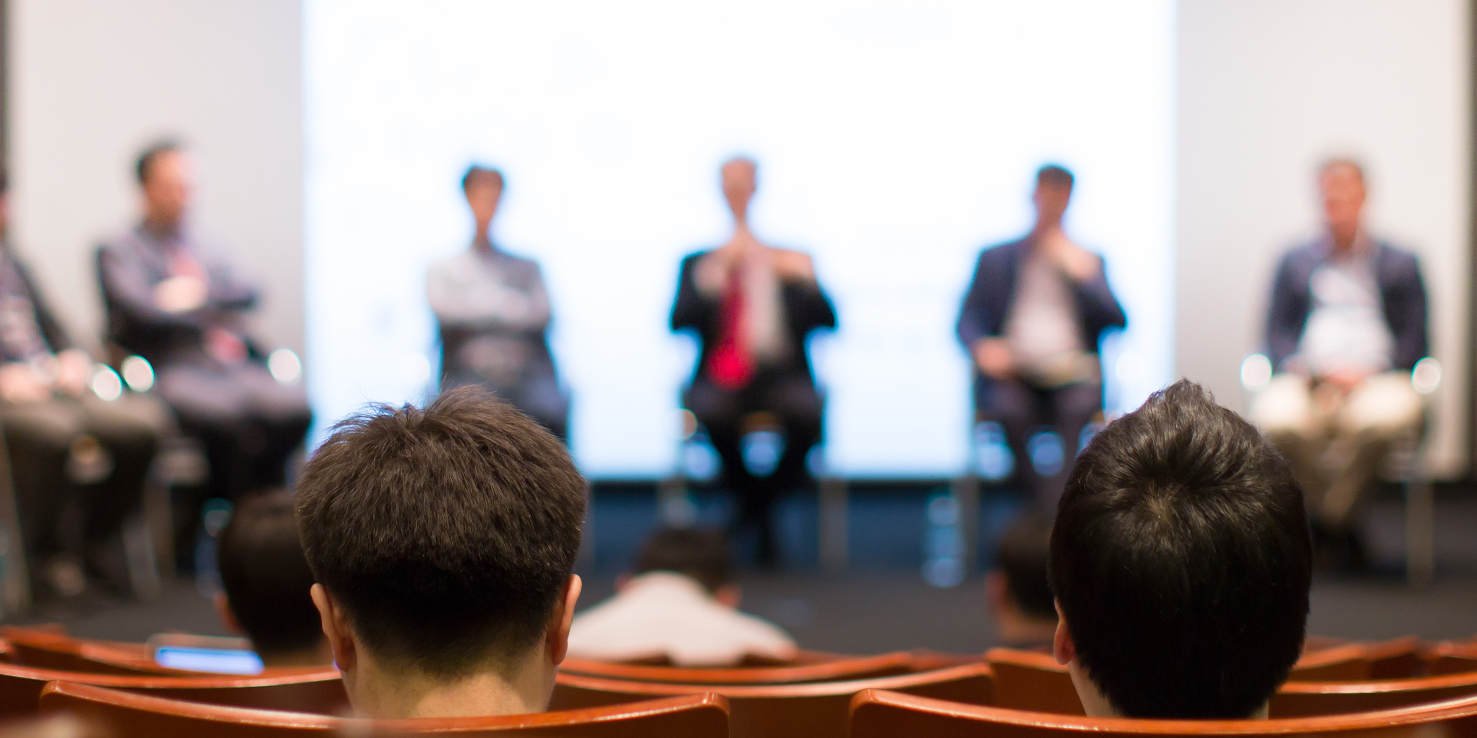 Panel of speakers on a stage.