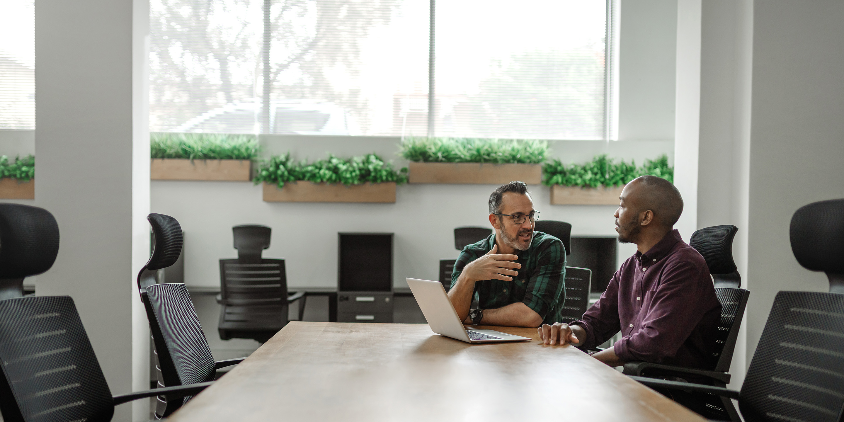 Employees talking at a conference room table.