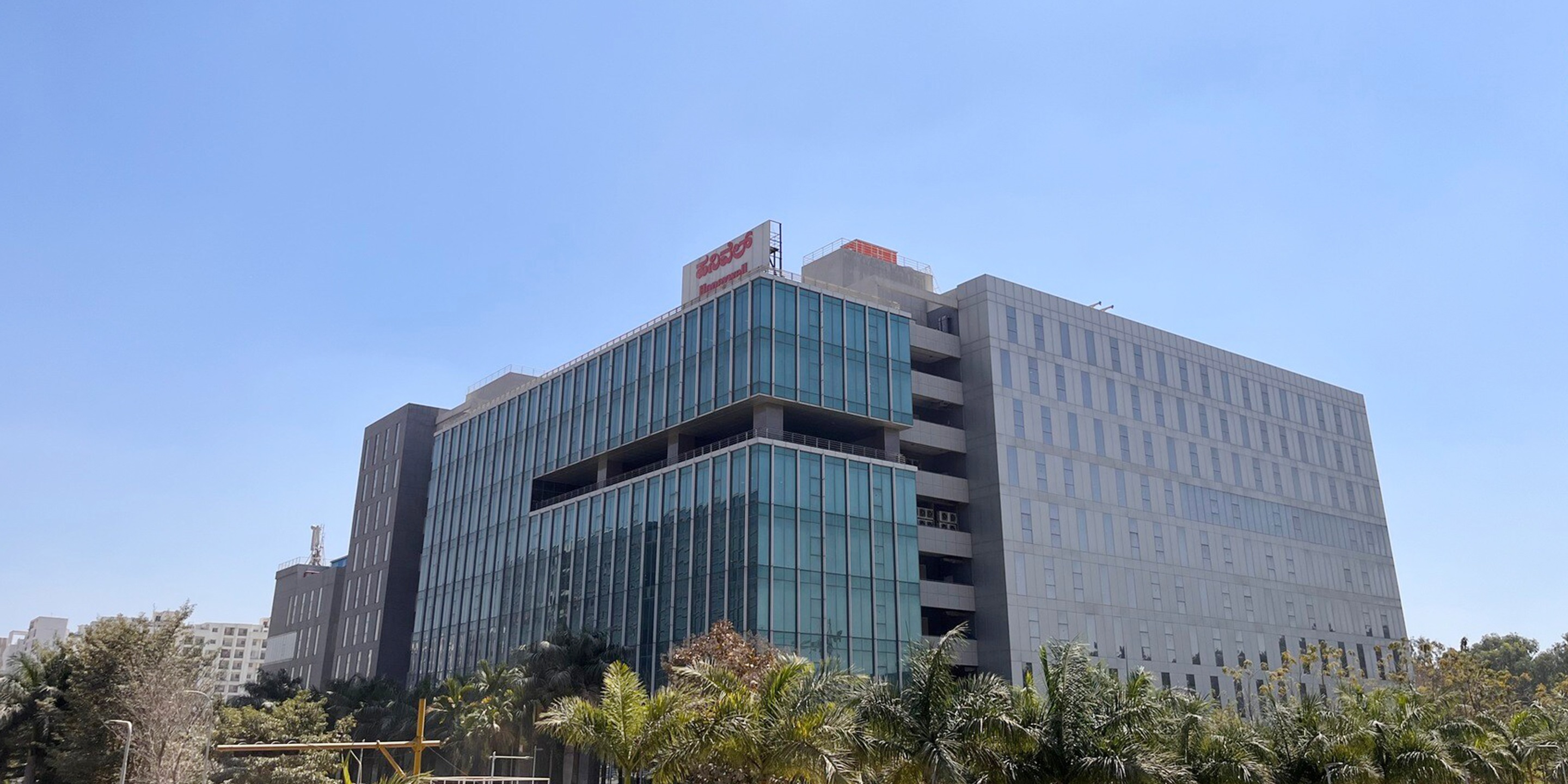 Contemporary office complex in Bangalore featuring glass facade and urban landscaping.