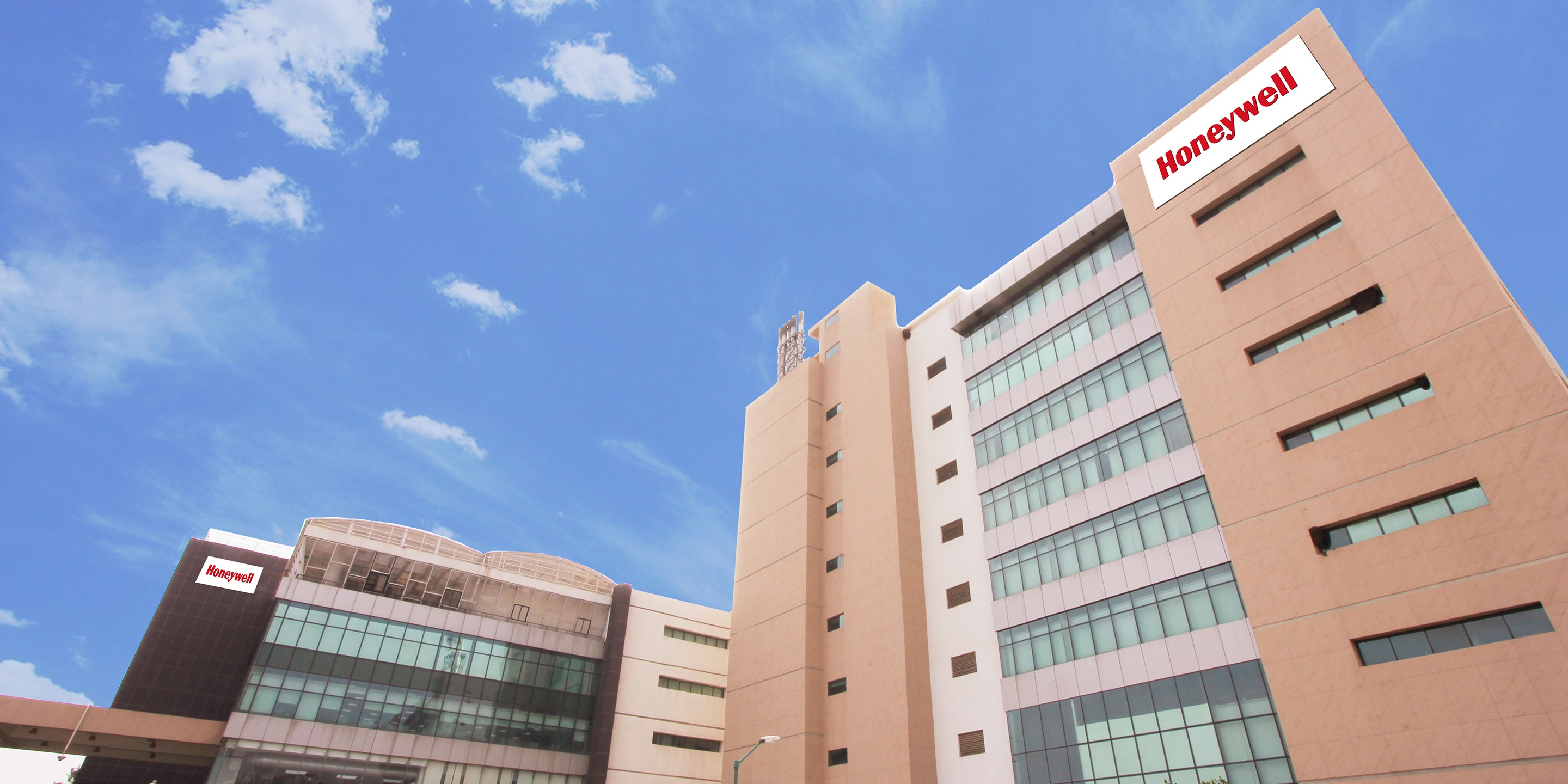 Modern Honeywell campus building in Bangalore with glass facade under a clear blue sky.