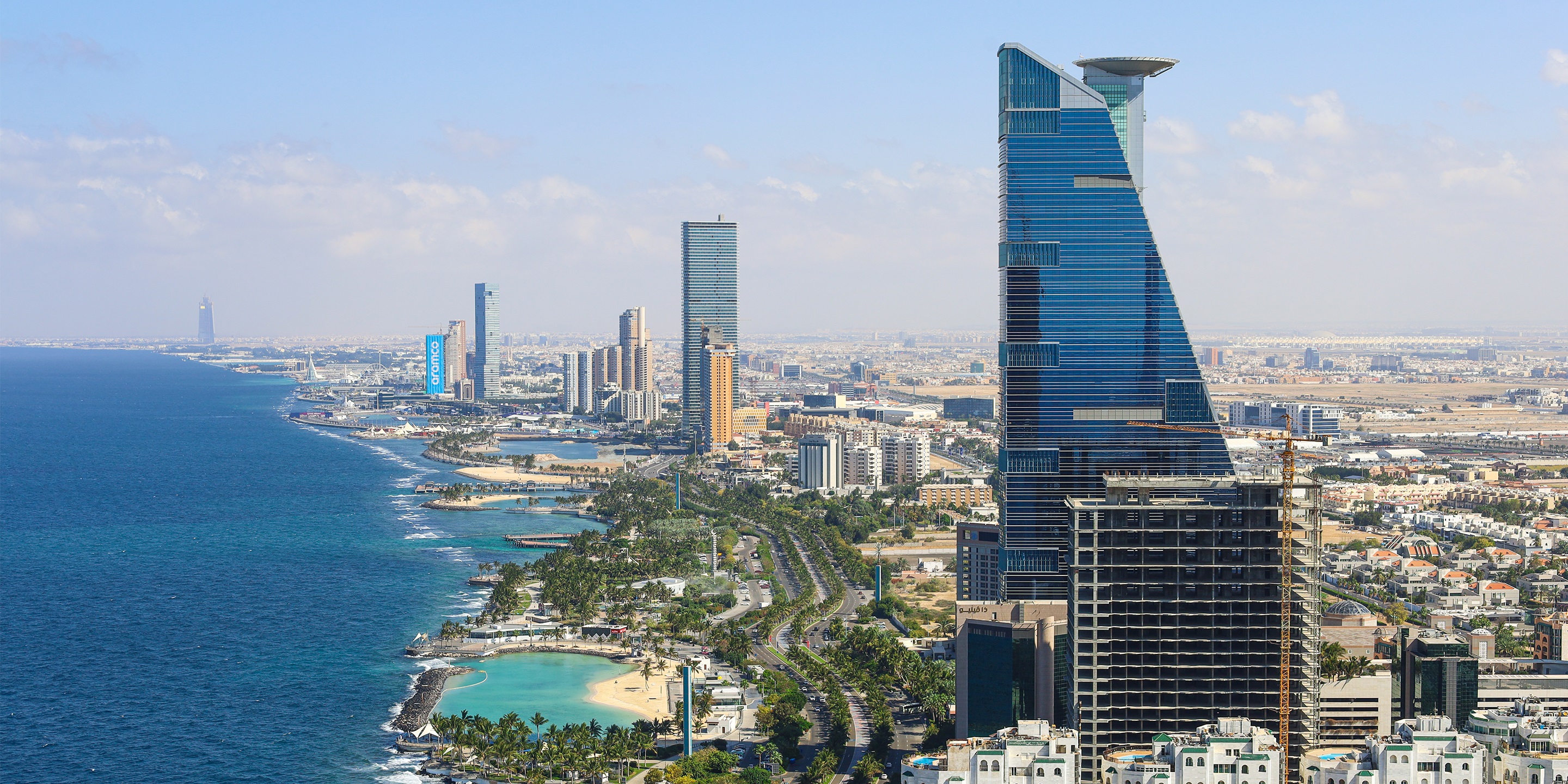 Aerial view of Jeddah skyline with modern towers along the Red Sea waterfront.