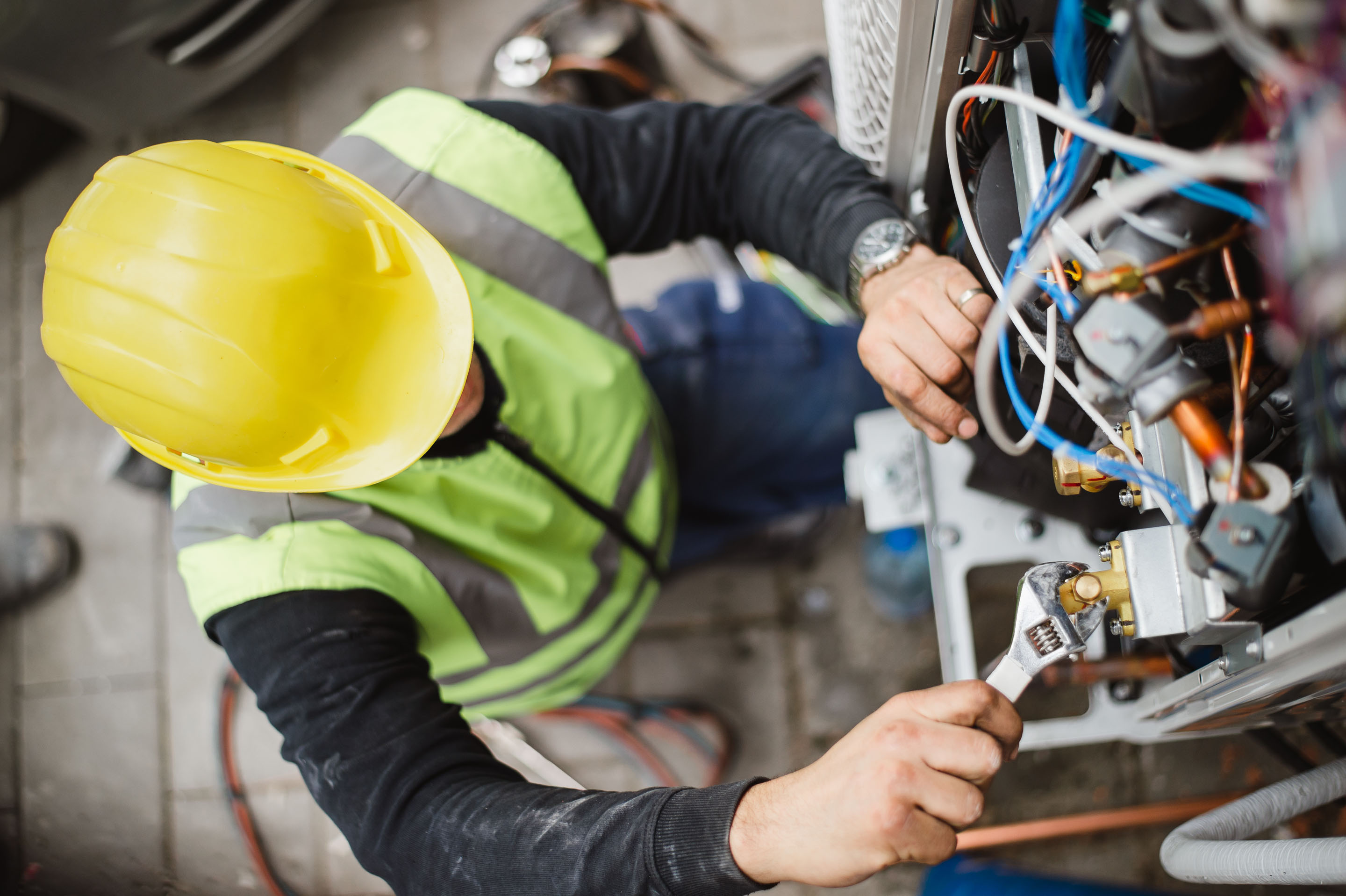 hon-hvac-technician-servicing-air-conditioning-unit-1291724300.jpg