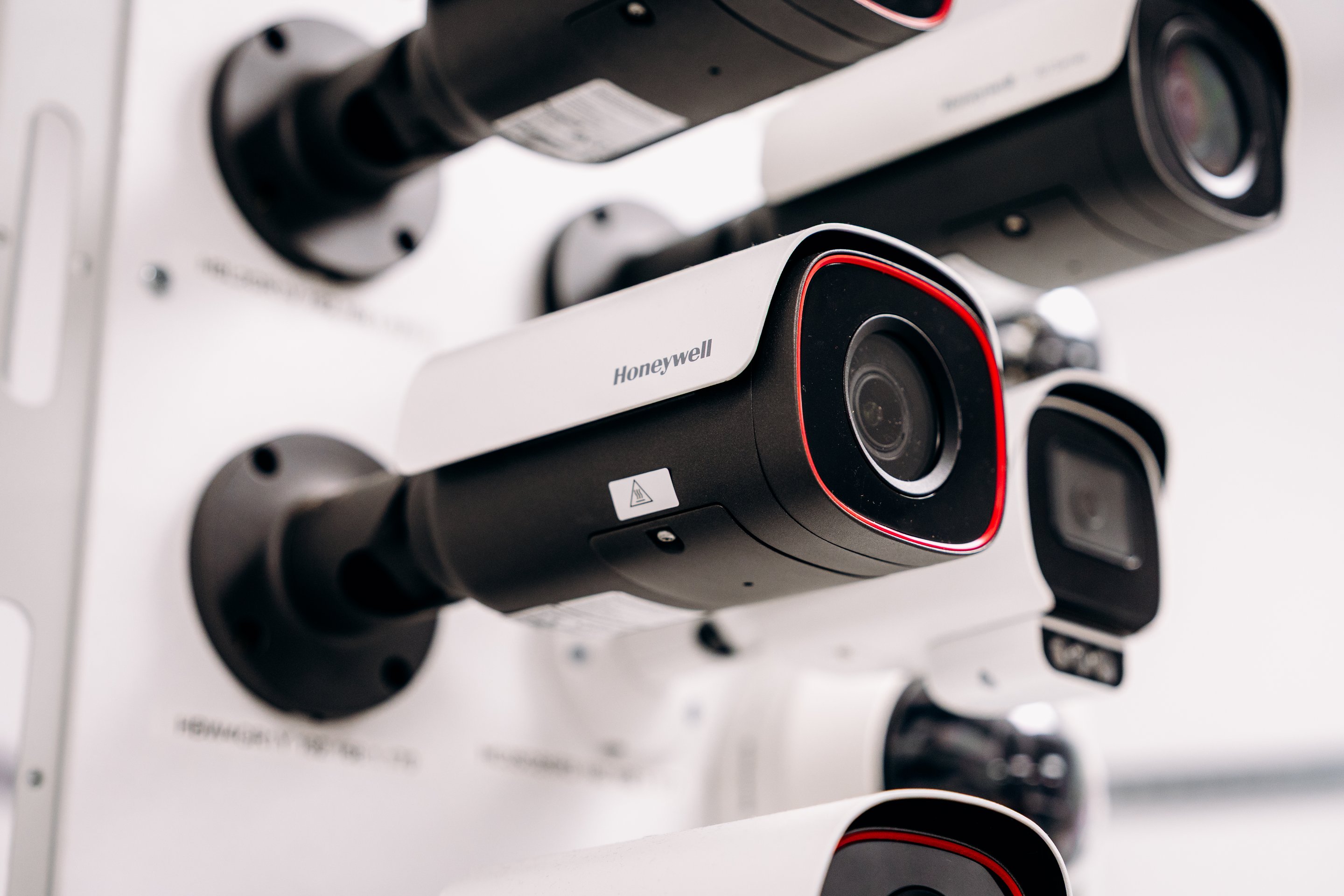 A close-up shot of professional Honeywell surveillance cameras mounted on a display board for corporate industrial monitoring solutions.