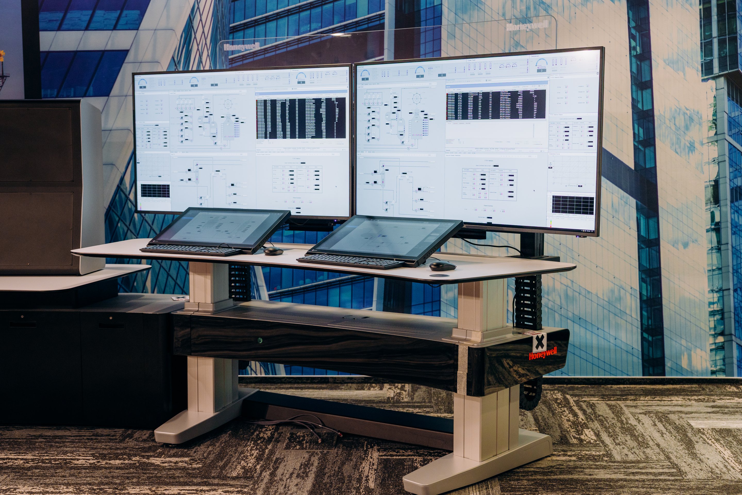 A modern Honeywell industrial workstation featuring dual large monitors and slanted touch displays for technical monitoring and process control.