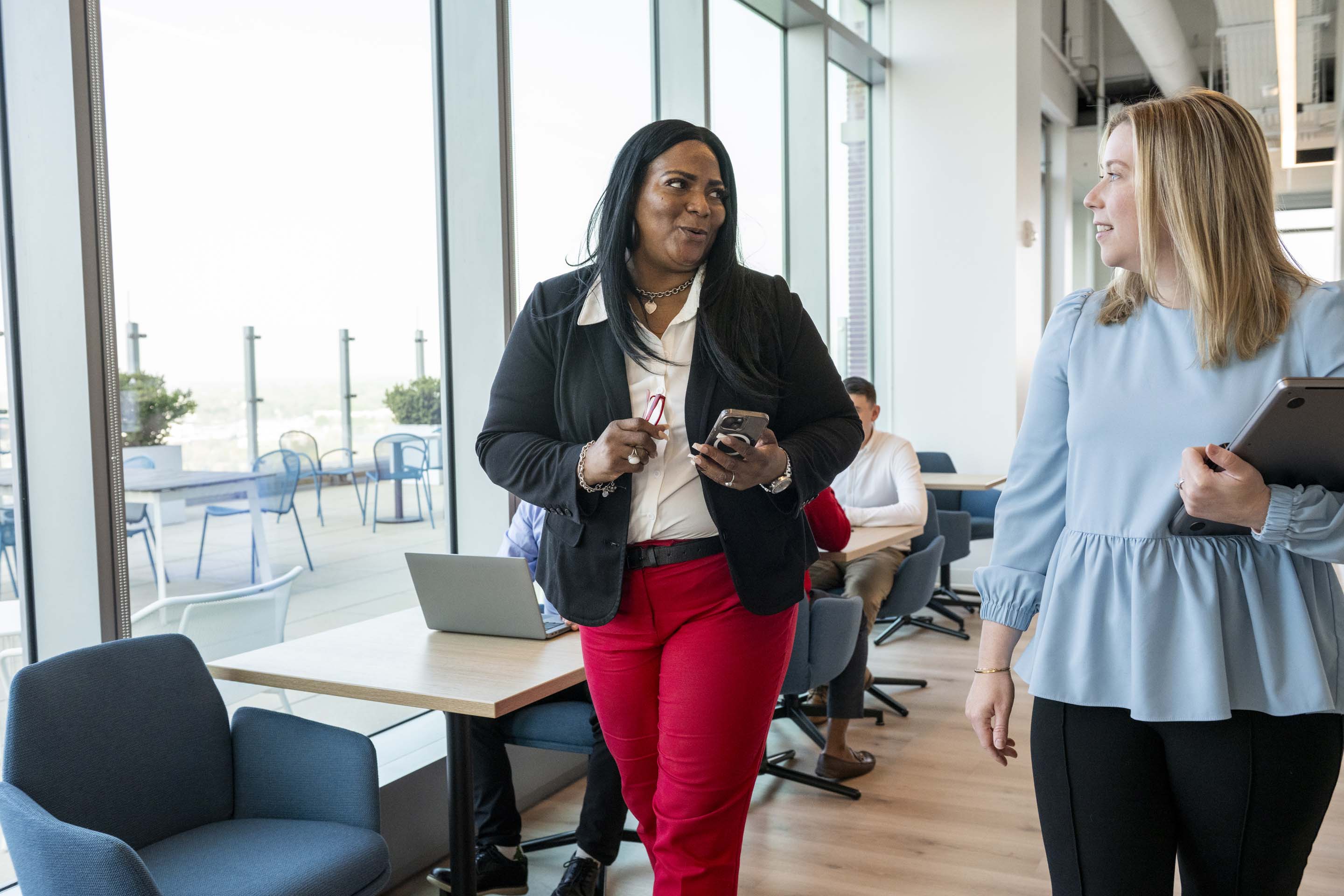 Employees interacting in a contemporary office meeting area, capturing teamwork, communication, and business collaboration in a professional environment.