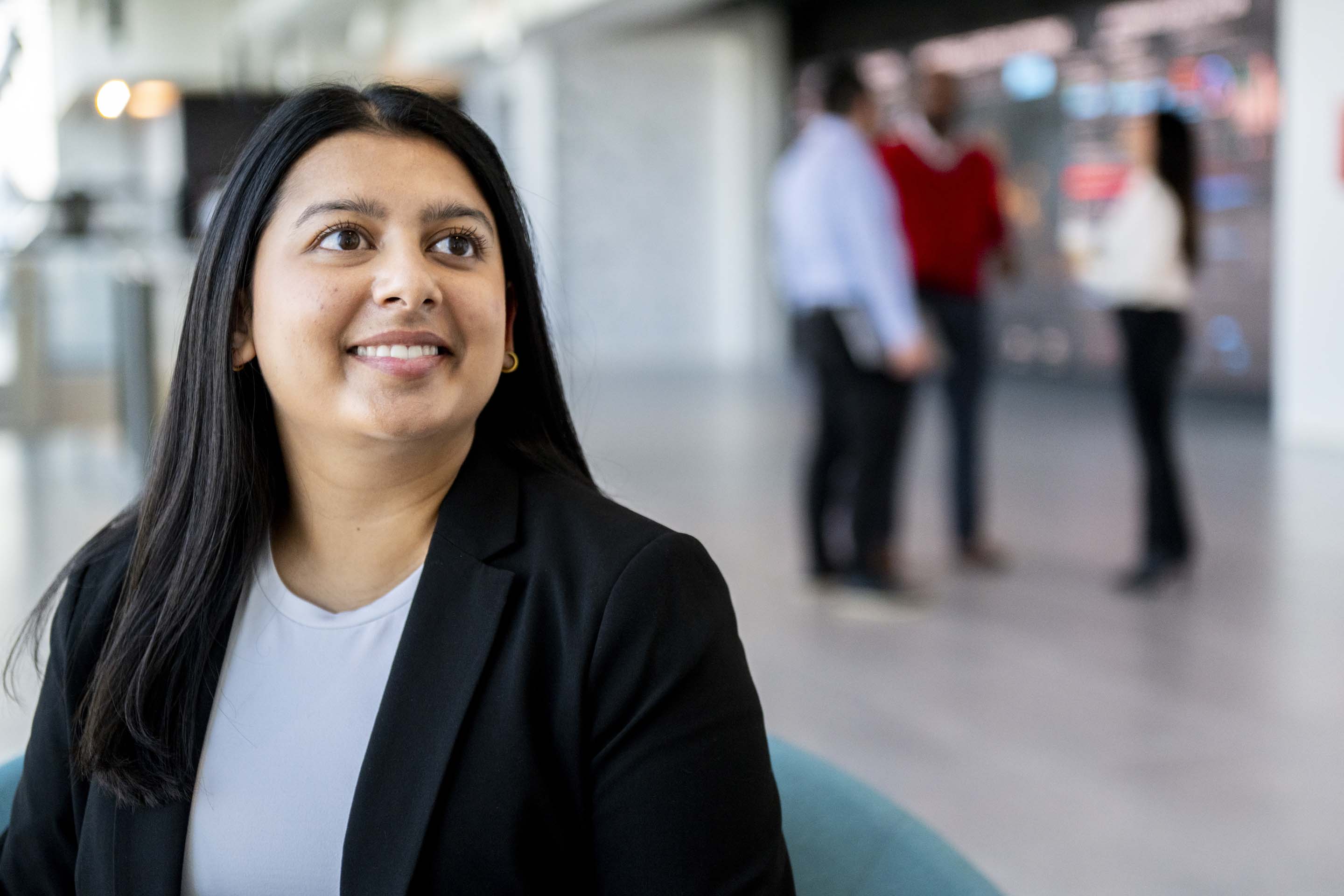 Close-up portrait of a professional employee seated in a contemporary office environment, highlighting workplace culture, confidence, and corporate branding.