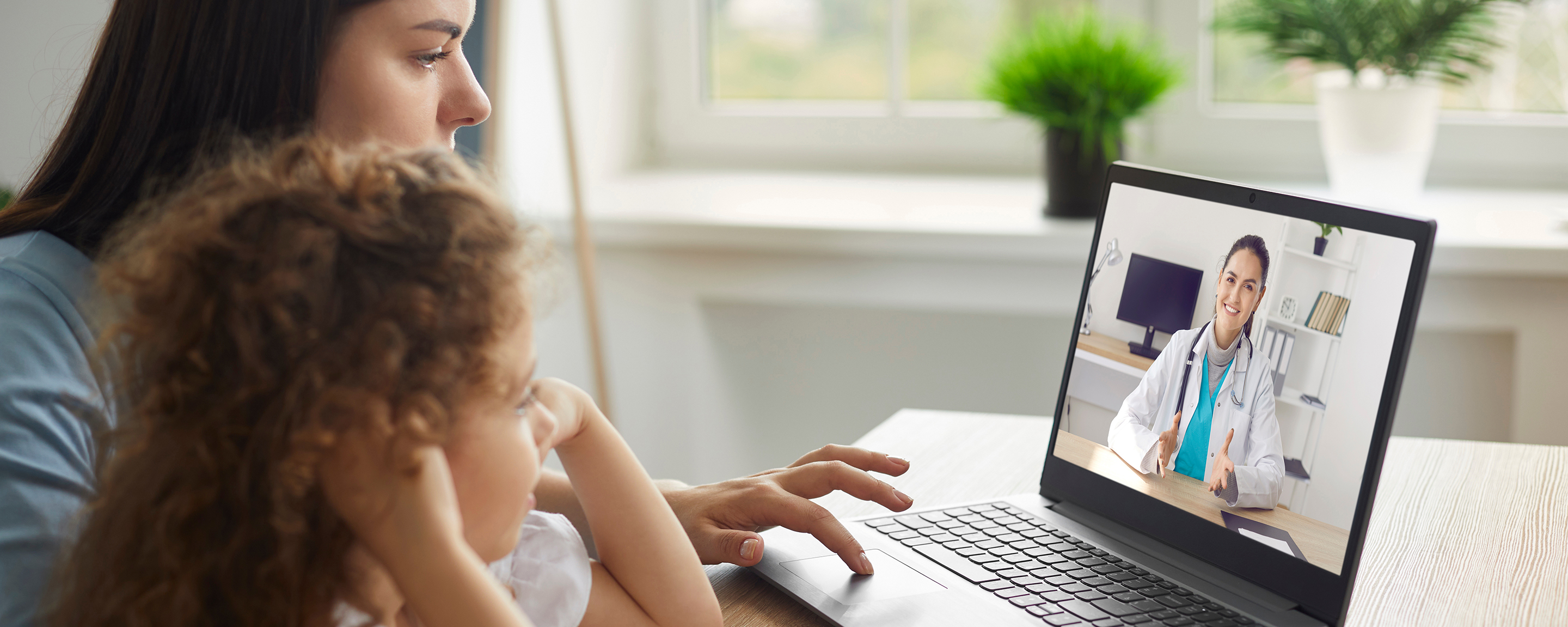 Healthy mother and child enjoying digital era, having online telemedicine consultation with remote doctor or watching educational video by professional paediatrician about cold and flu virus treatment