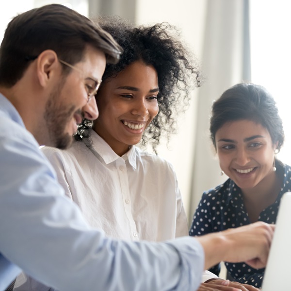 People sharing ideas in front of a monitor
