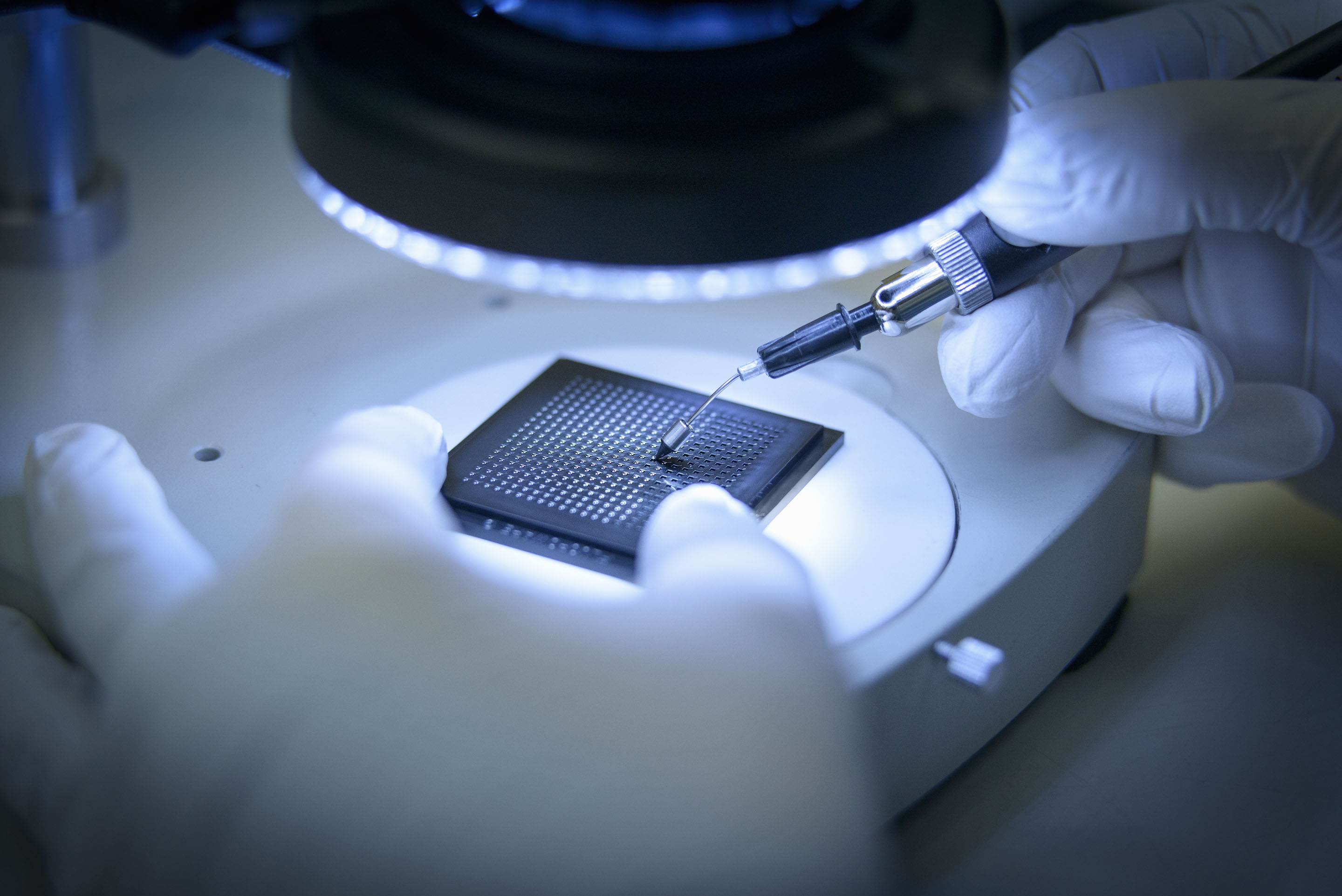 hon-gloved-technician-probing-semiconductor-chip-microscope-556415427.jpg