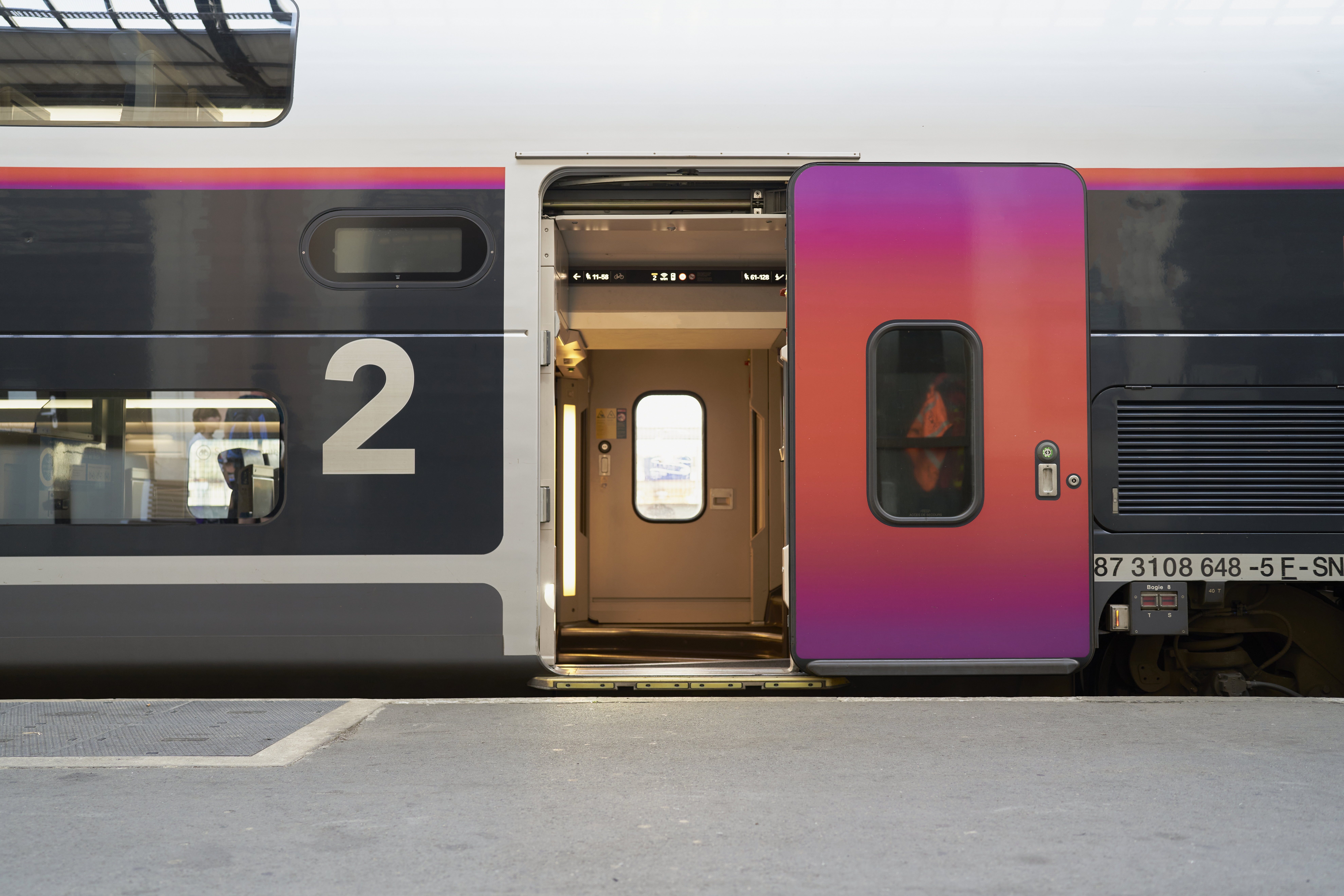 train door at the station open waiting for people to enter seen from a corner with glass windows
