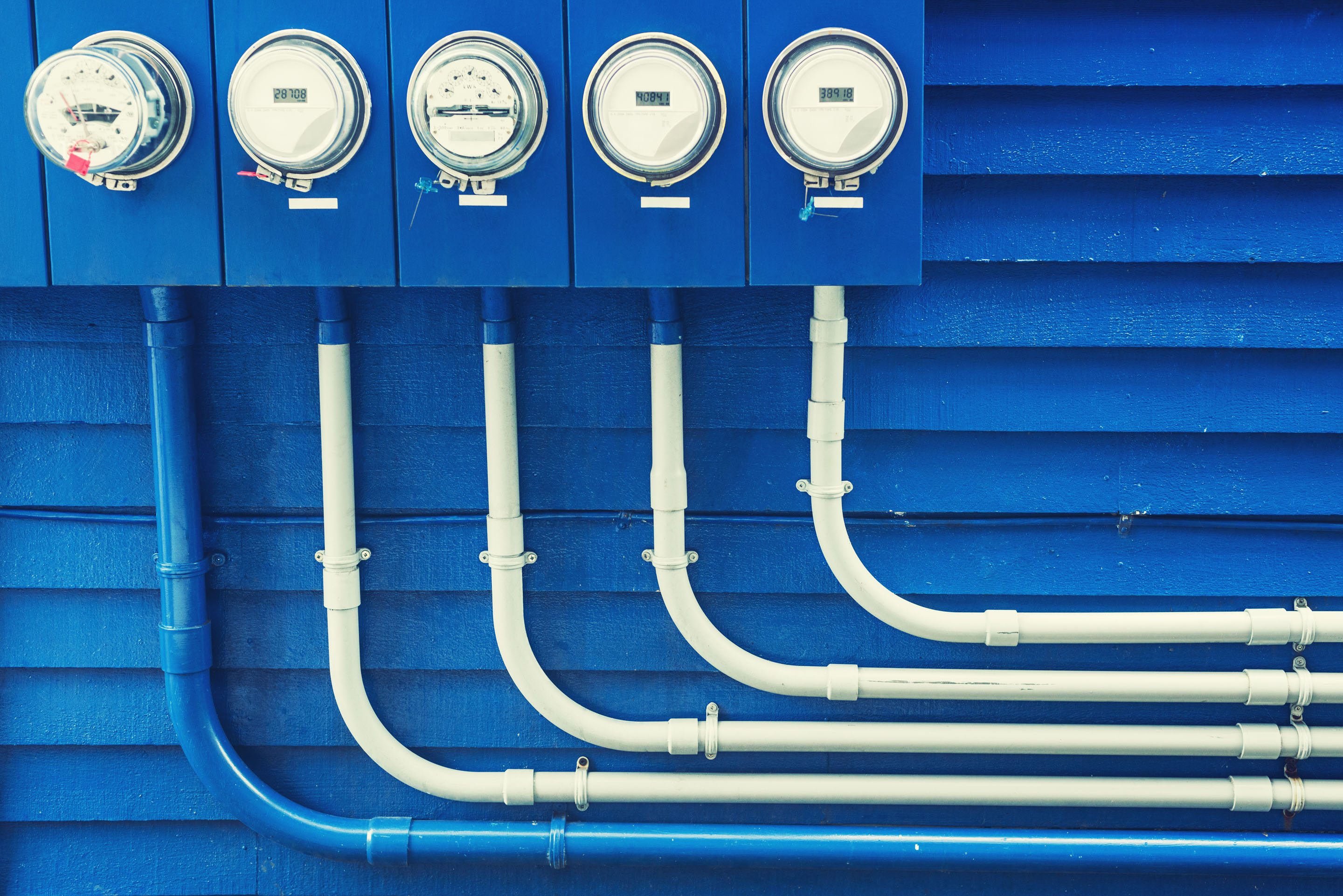 hon-electric-utility-meters-conduit-pipes-blue-wall-161049597.jpg