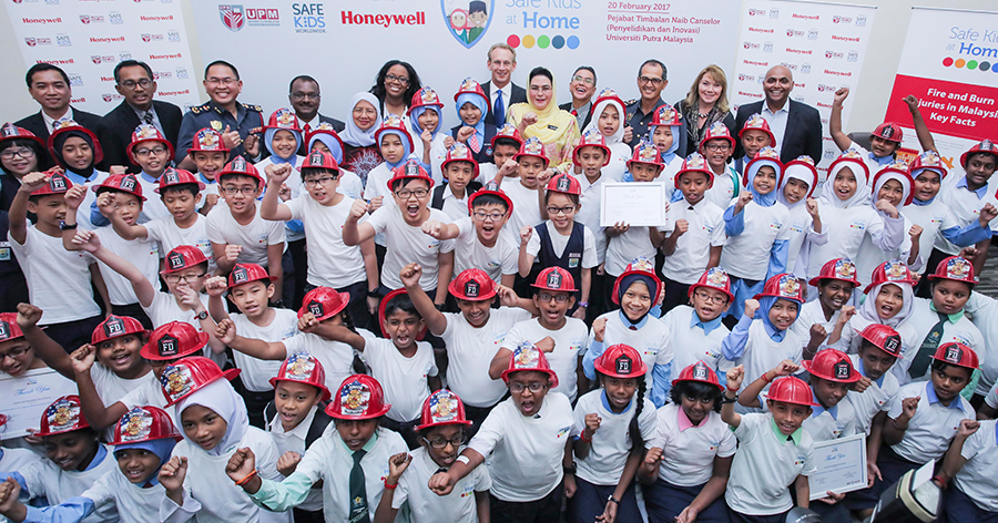 A large group of children and adults participating in a safety awareness programme, promoting fire safety education, community engagement, and public safety initiatives.