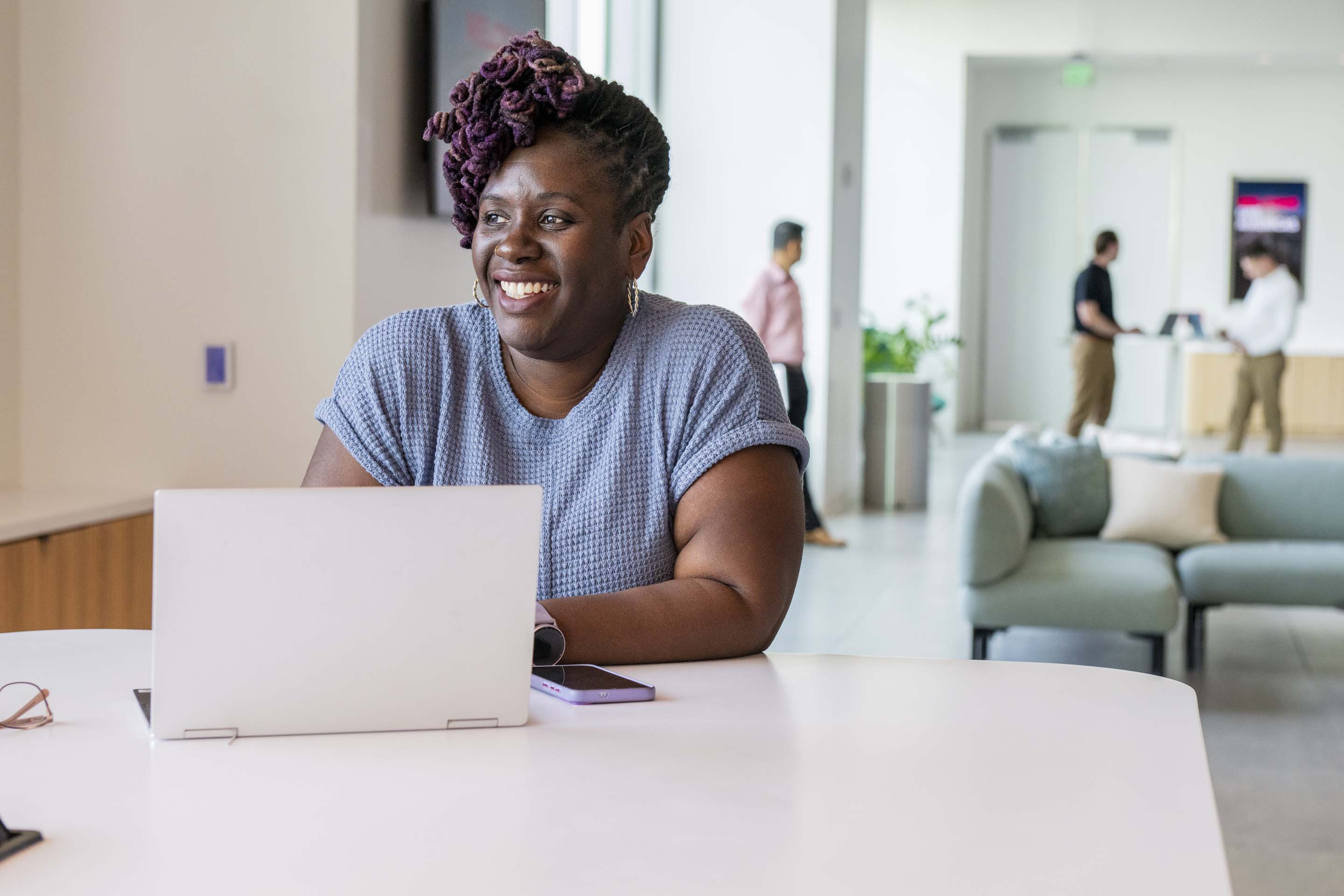 Individual working on a laptop in a bright modern office environment, showcasing productivity, focus, and flexible workspace design.