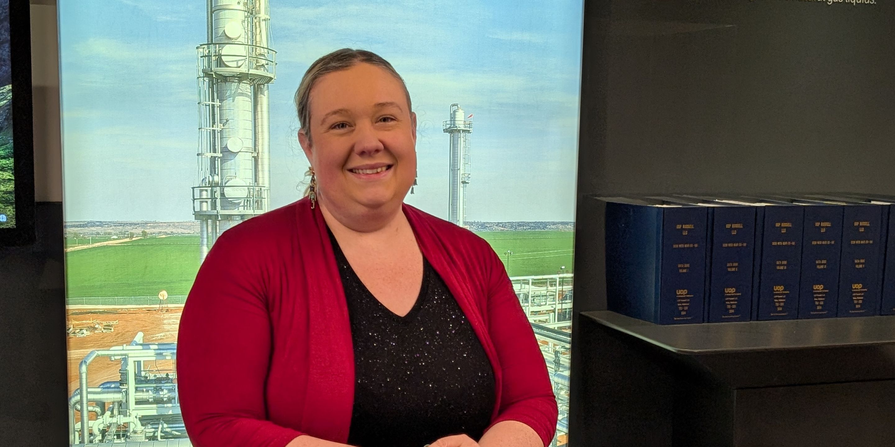 Christina Jackson smiles in front of a Honeywell UOP background.