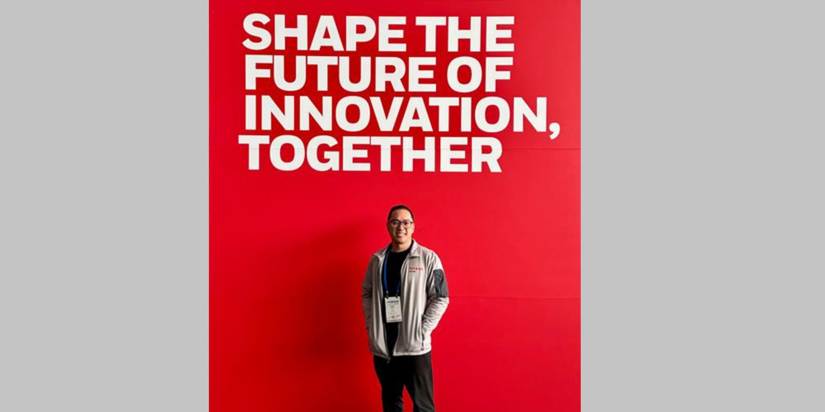 Honeywell Aerospace Technologies engineer Charles is pictured in front of a red backdrop at an event that reads "Shape the future of innovation, together"
