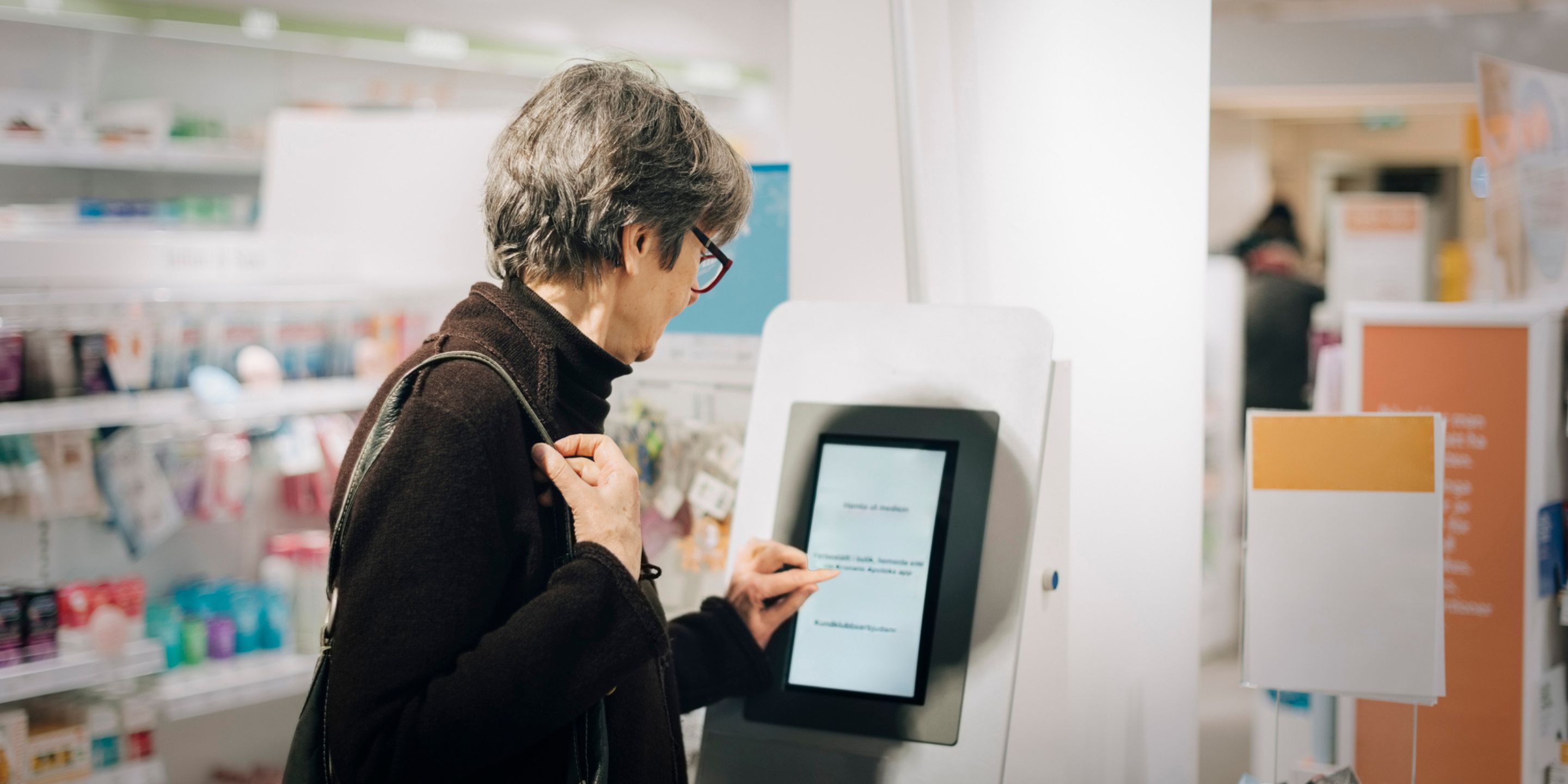 A shopper uses a device at a store to find more information on a product or get customer service support.