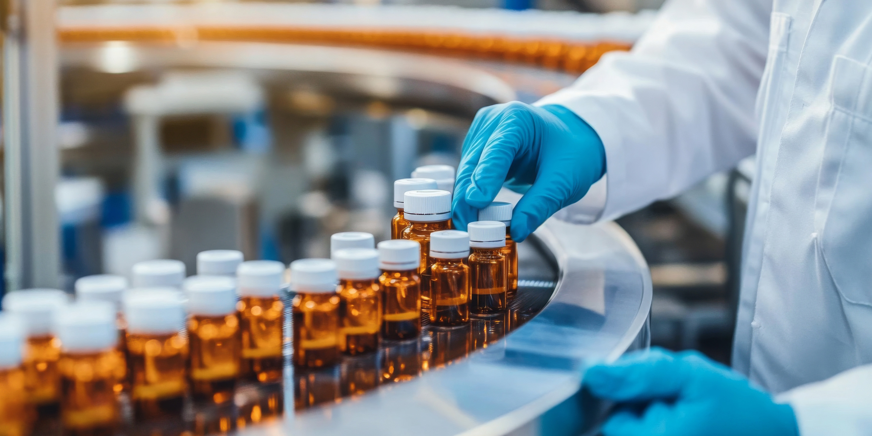 A close-up of a gloved hand placing amber bottles on a conveyor belt in a pharmaceutical manufacturing facility, highlighting the meticulous bottling process.