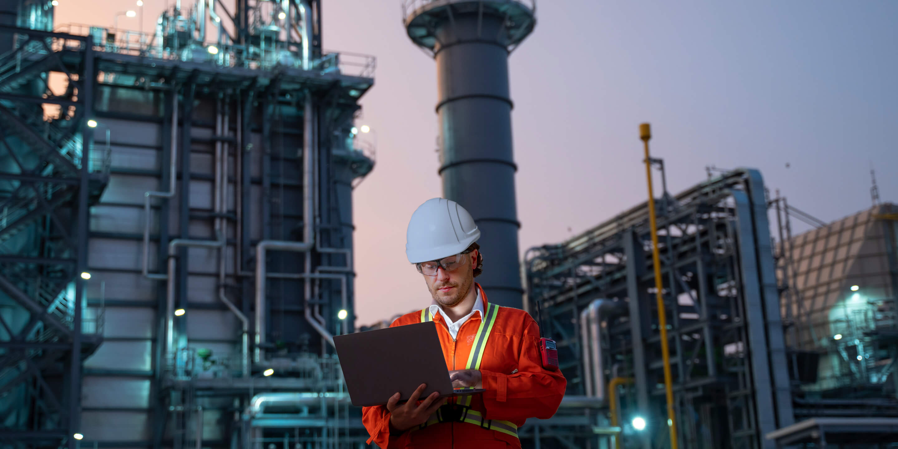 Service engineer is working at electric power plant with laptop