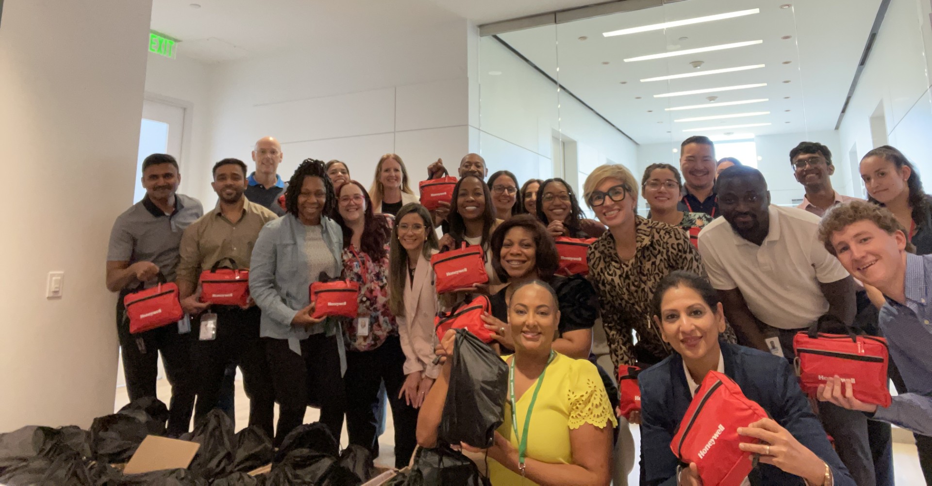 Group photo of employees holding Honeywell-branded kits, showcasing teamwork and engagement during an event.