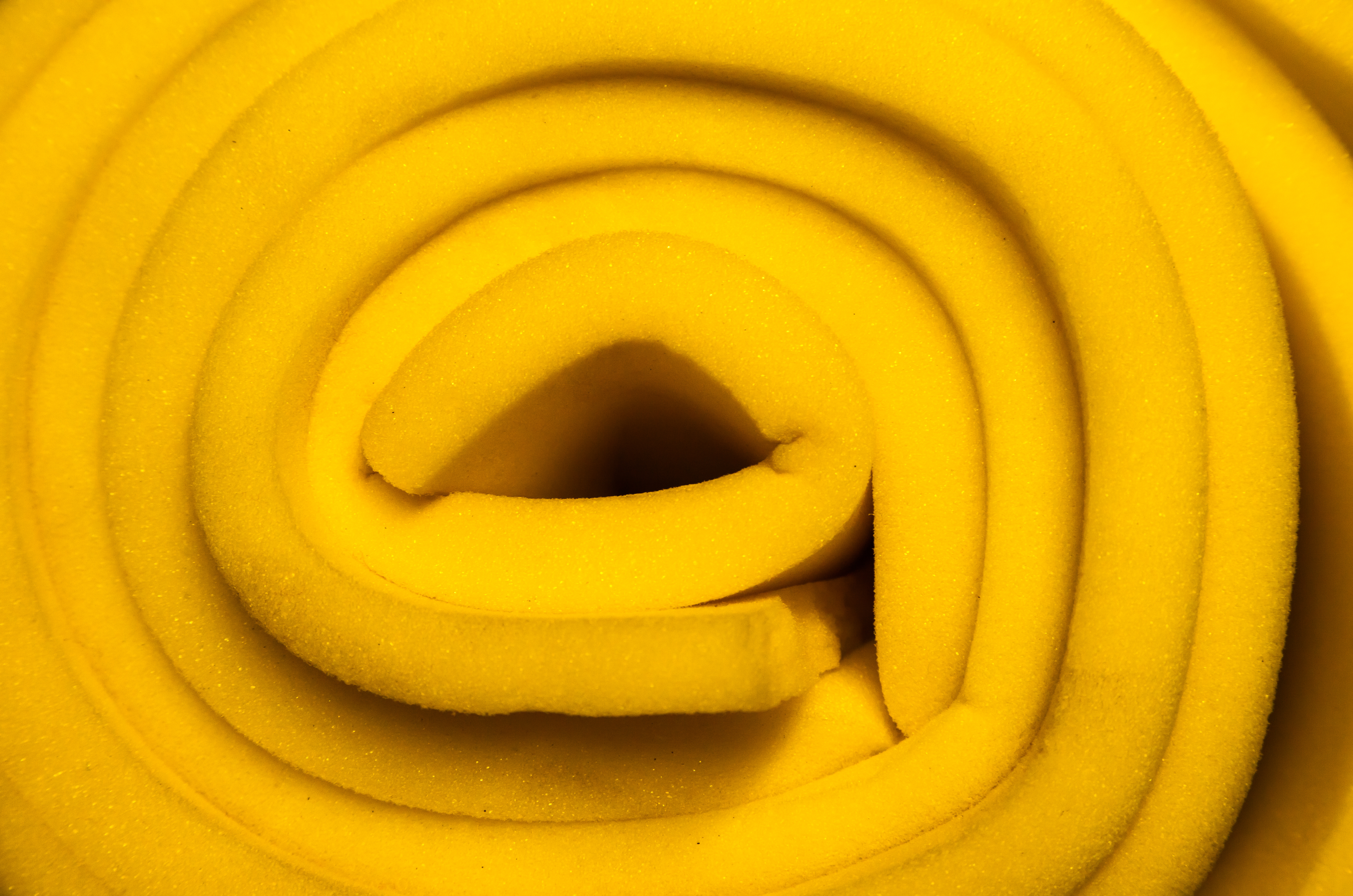 yellow foam rubber twisted into a roll, close-up.